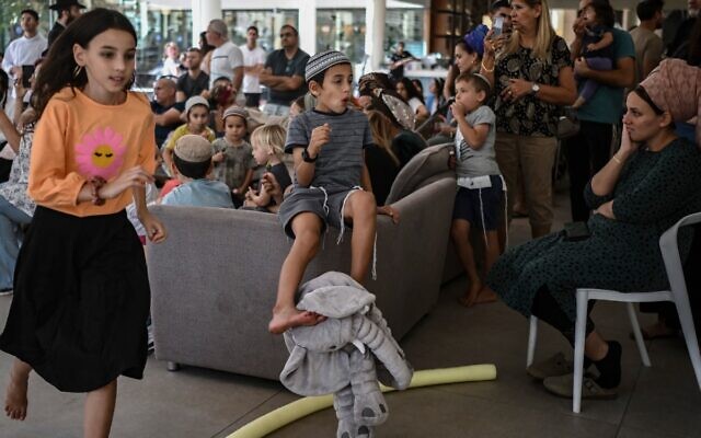 Evacuees from Kibbutz Nir Oz in the lobby of a hotel in Eilat on October 17, 2023. (Aris MESSINIS / AFP)