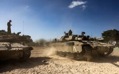 Merkava tanks roll into position outside Kibbutz Be'eri, near the border with the Gaza Strip on October 20, 2023. (RONALDO SCHEMIDT / AFP)