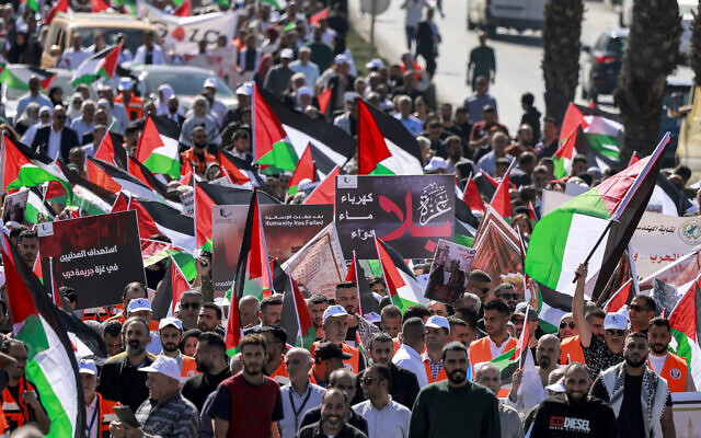 Protesters march with Palestinian flags during a rally in support with people in the Gaza Strip, in the city of Ramallah in the West Bank on October 25, 2023. (Photo by Jaafar ASHTIYEH / AFP)