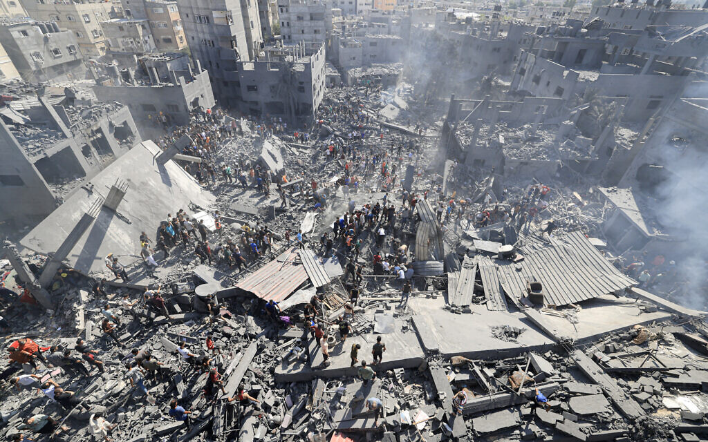 People search for survivors and for bodies of victims through the rubble of buildings destroyed during Israeli airstrikes, in Khan Younis in the southern Gaza Strip, October 26, 2023, amid the ongoing war between Israel and Palestinian terror group Hamas. (Mahmud Hams/AFP)