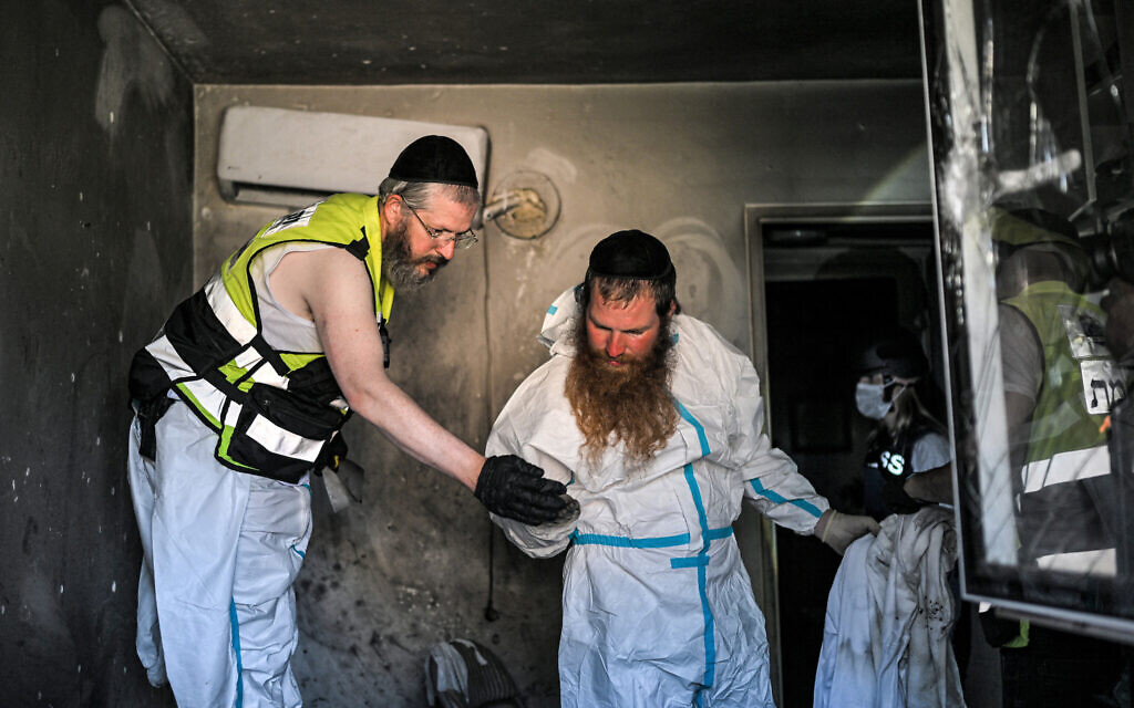 Volunteers of the Israeli ultra-Orthodox NGO ZAKA collect samples in one of the houses attacked by Hamas terrorists in the October 7 massacre, in Kibbutz Holit in Israel's southern district south of the Gaza Strip, October 26, 2023. (Photo by YURI CORTEZ / AFP)