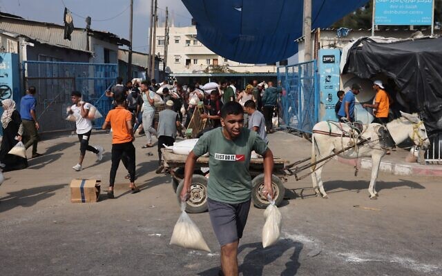 Palestinians storm a UN-run aid supply center, that distributes food to displaced families following Israel's call for more than one million residents in northern Gaza to move south for their safety, in Deir el-Balah on October 28, 2023. (MOHAMMED ABED/AFP)