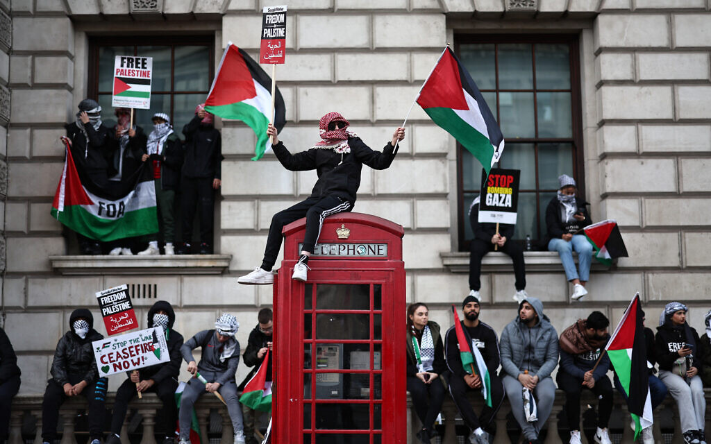 Protesters hold placards and wave Palestinian flags during a 'March For Palestine' in London on October 28, 2023, as they call for ceasefire in the war between Israel and Hamas. (Henry Nicholls/AFP)