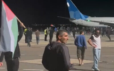 This frame grab taken from video footage posted on the Telegram channel @askrasul on October 29, 2023 shows a mob looking for Jews and Israelis on the apron area of an airport in Makhachkala. (Photo by Telegram / @askrasul / AFP)