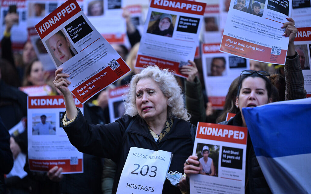 People hold up posters of the missing as they gather outside the Qatari Embassy in London on October 29, 2023, to demand the release of the estimated 240 hostages held in Gaza by Hamas. (Justin TALLIS / AFP)