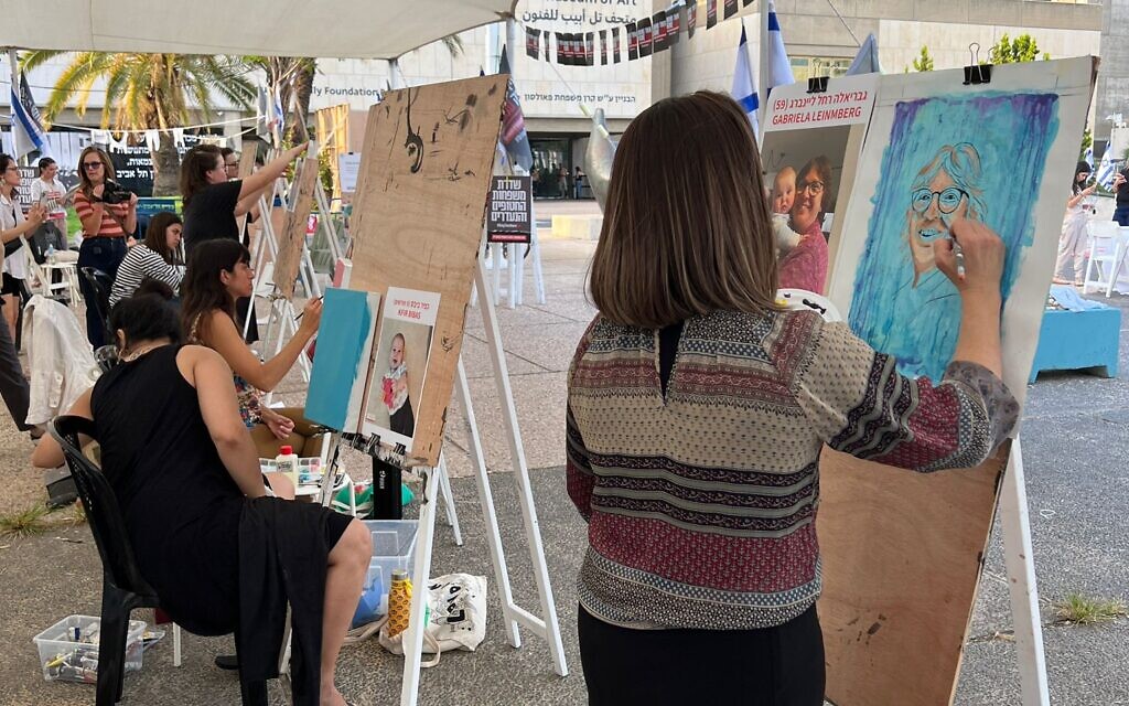 Artists paint portraits of Israeli hostages held by Hamas terrorists as part of the This is Us project at the Tel Aviv Museum of Art, October 26, 2023. (Courtesy Yotzrim Seviva)
