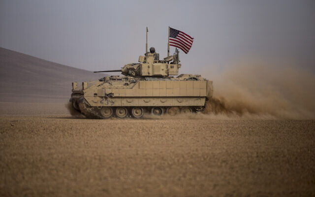 Illustrative: American soldiers drive a Bradley fighting vehicle during a joint exercise with Syrian Democratic Forces at the countryside of Deir Ezzor in northeastern Syria, December 8, 2021. (Baderkhan Ahmad/AP)