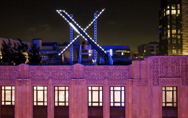 Workers install lighting on an 'X' sign atop the company headquarters, formerly known as Twitter, in downtown San Francisco, July 28, 2023. (Noah Berger/AP)