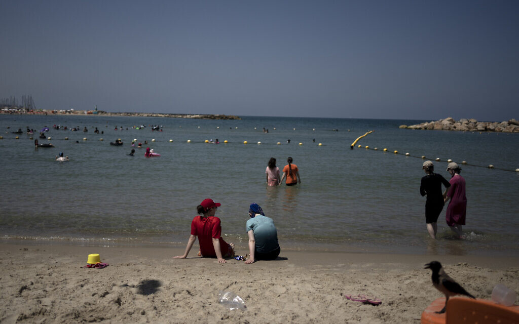 Religious and secular women take refuge from a summer heat wave at a public beach on one of three days in the week designated for women in Tel Aviv, Israel on July 13, 2023. (AP Photo/Maya Alleruzzo, File)