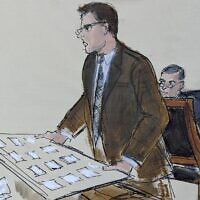 In this courtroom sketch, FTX founder Sam Bankman-Fried, second from right, seated at defense table, looks behind as Courtroom Deputy Andrew Mohan, center, holds a seating diagram while announcing the jury's seating order for Bankman-Fried's fraud trial, Tuesday, Oct. 3, 2023, in New York. (AP Photo/Elizabeth Williams)