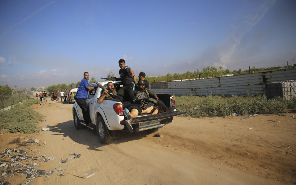 Palestinian terrorists drive to the Gaza Strip with what is believed to be the body of an Israeli woman, on October 7, 2023. (AP/Ali Mahmud)