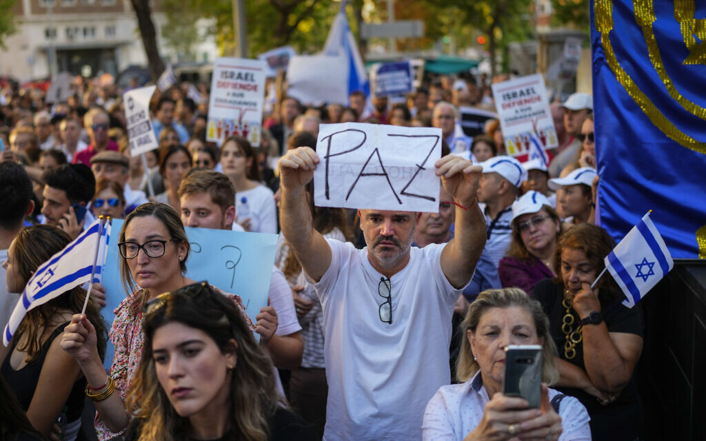 A man holds a sign reading "Peace" in Spanish during a pro-Israeli gathering outside the Israeli embassy in Madrid, Spain, Tuesday, Oct. 10, 2023. The latest Israel-Palestinian war reverberated around the world Tuesday, as foreign governments tried to determine how many of their citizens were dead, missing or in need of medical help or flights home. (AP Photo/Manu Fernandez)