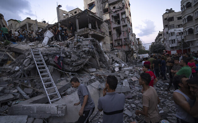 Palestinians look for injured in the rubble of a destroyed building following an Israeli airstrike, Tuesday, Oct. 10, 2023. (AP Photo/Fatima Shbair)
