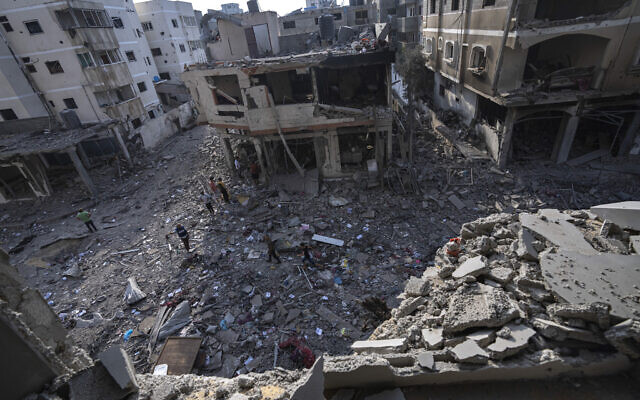Palestinians walk through the destruction after an Israeli bombing in Gaza City on Wednesday, Oct. 11, 2023. (AP/Fatima Shbair)