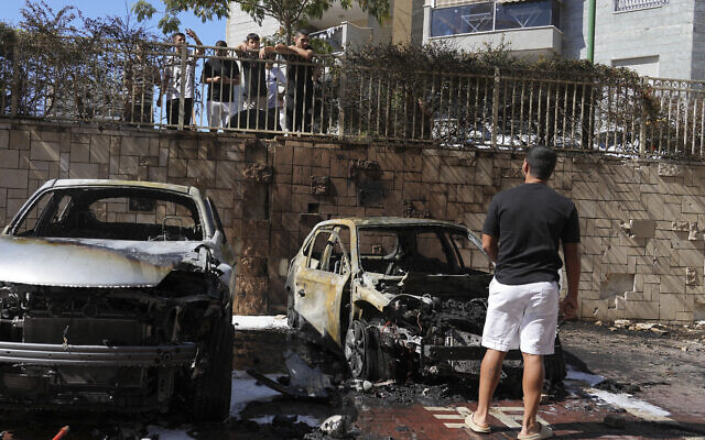 Israelis inspect damaged cars after they were hit by a rocket fired from the Gaza Strip in Ashkelon, southern Israel, October 13, 2023. (AP Photo/Tsafrir Abayov)