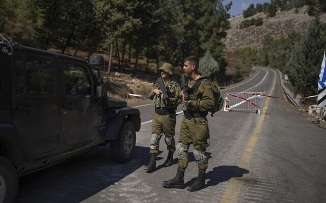 Israeli soldiers guard a check point near the border with Lebanon, Saturday, Oct. 14, 2023. (AP Photo/Petros Giannakouris)