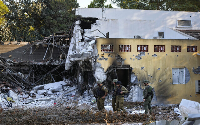 Israeli soldiers walk past houses destroyed by Hamas terrorists in Kibbutz Be'eri, October 14, 2023. (AP Photo/Ariel Schalit)