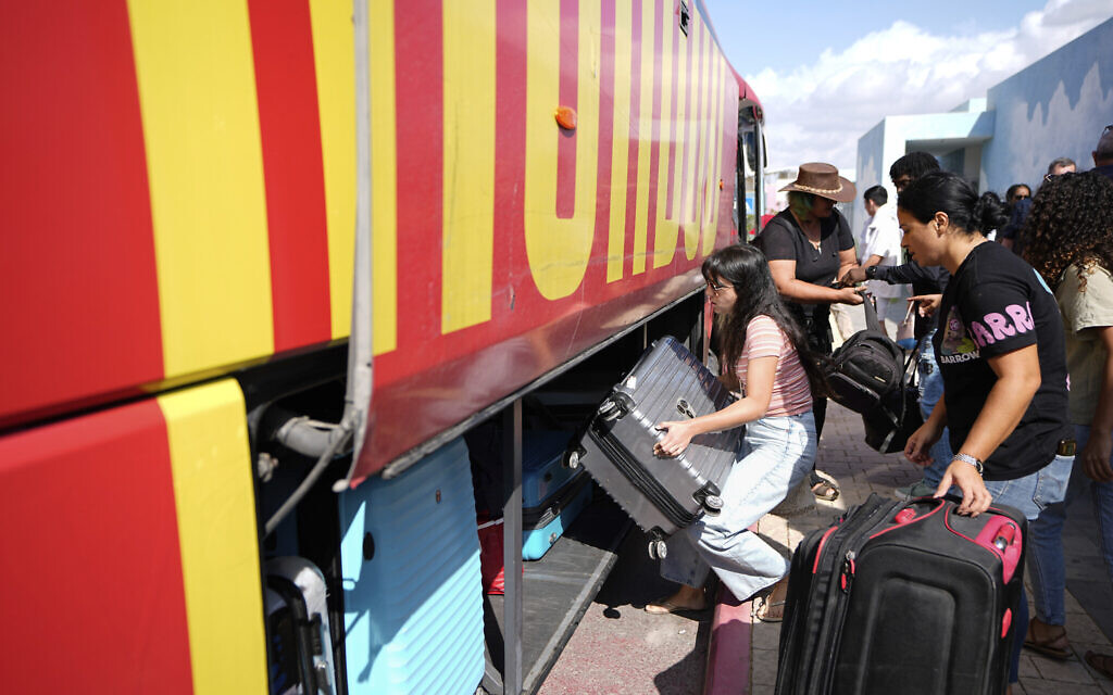 Israelis load their belongings onto a bus as they evacuate from the southern Israeli town of Sderot, Oct. 15, 2023. (AP Photo/Ariel Schalit)