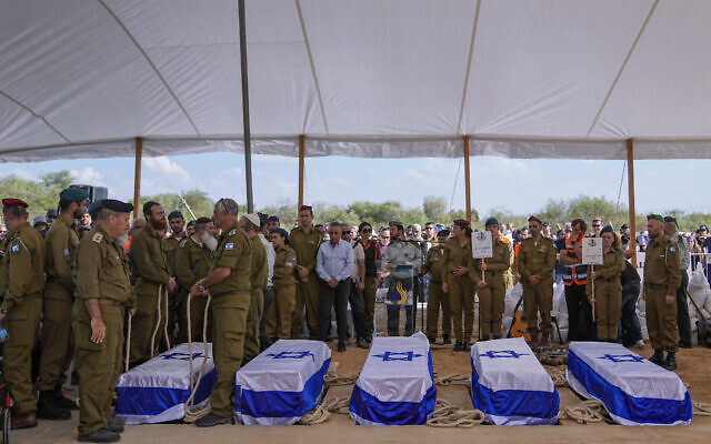 Mourners gather around the five coffins of the Kotz family during their funeral in Gan Yavne, Israel, October 17, 2023. (Ohad Zwigenberg/ AP)