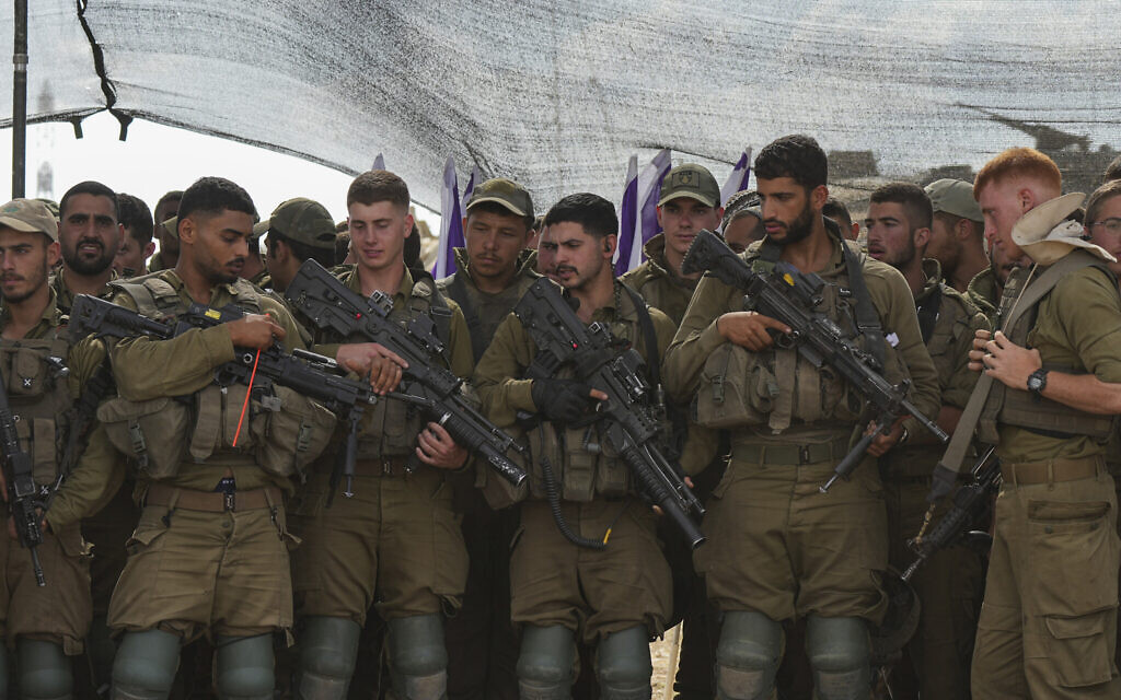Israeli soldiers listen to Israel's Defense Minister Yoav Gallant, during his visit to a staging area near the border with the Gaza Strip in southern Israel, Thursday, Oct. 19, 2023. (AP Photo/Tsafrir Abayov)