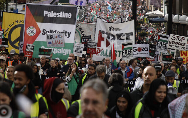Demonstrators hold up flags and placards during a pro-Palestinian rally, amid the ongoing Israel-Hamas war, in London, October 21, 2023. (AP Photo/David Cliff)