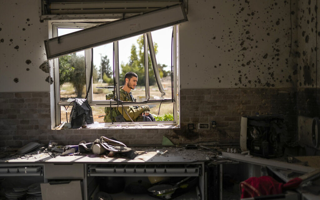 An Israeli soldier patrols next to a house damaged by Hamas terrorists at Kibbutz Kissufim in southern Israel, Oct. 21, 2023. (AP/Francisco Seco)