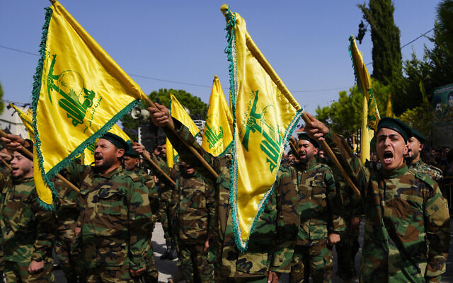 Hezbollah fighters raise their group's flag and shout slogans, as they attend the funeral procession of Hezbollah fighter, Bilal Nemr Rmeiti, who was killed by Israeli shelling, during his funeral procession in Majadel village, south Lebanon, Sunday, Oct. 22, 2023. (AP Photo/Hassan Ammar)