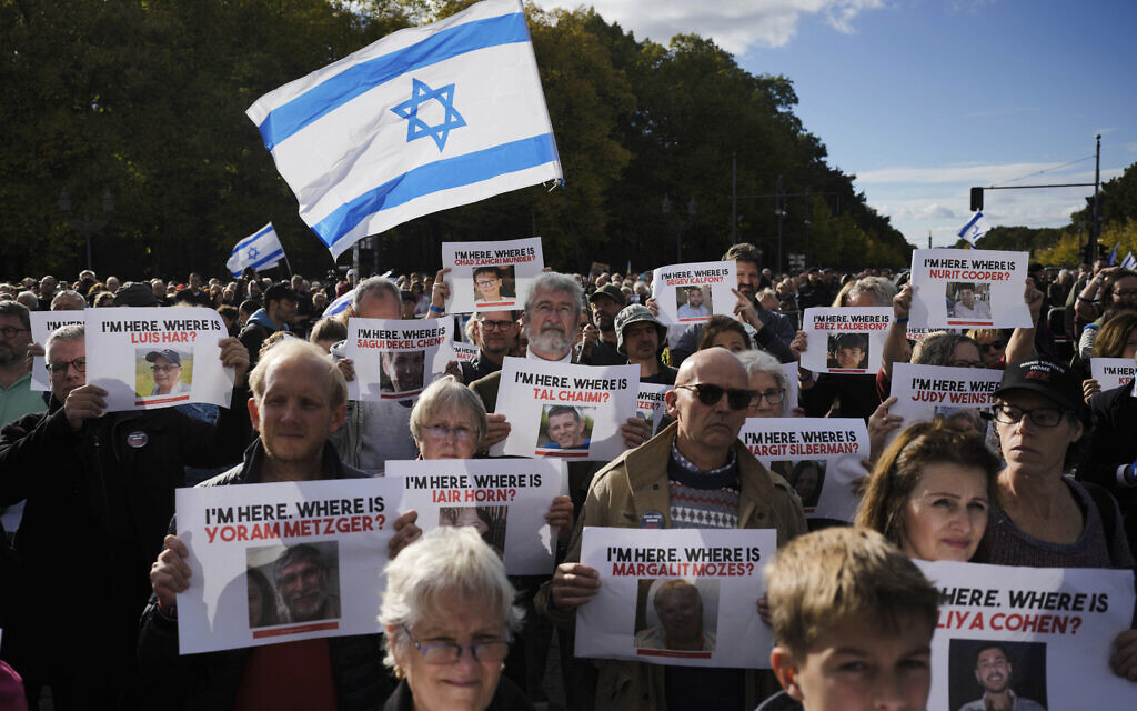 People wave Israeli flags and show posters from people reported to be missing or held by Hamas as hostages, during a demonstration against antisemitism and to show solidarity with Israel in Berlin, Germany, October 22, 2023. (AP Photo/Markus Schreiber)