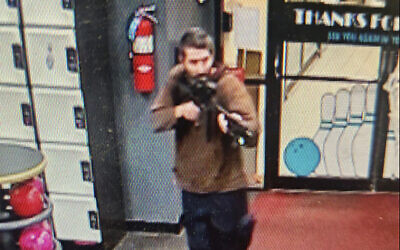 In this image taken from video released by the Androscoggin County Sheriff's Office, an unidentified gunman points a gun while entering Sparetime Recreation in Lewiston, Maine, on Octber 25, 2023. (Androscoggin County Sheriff's Office via AP)