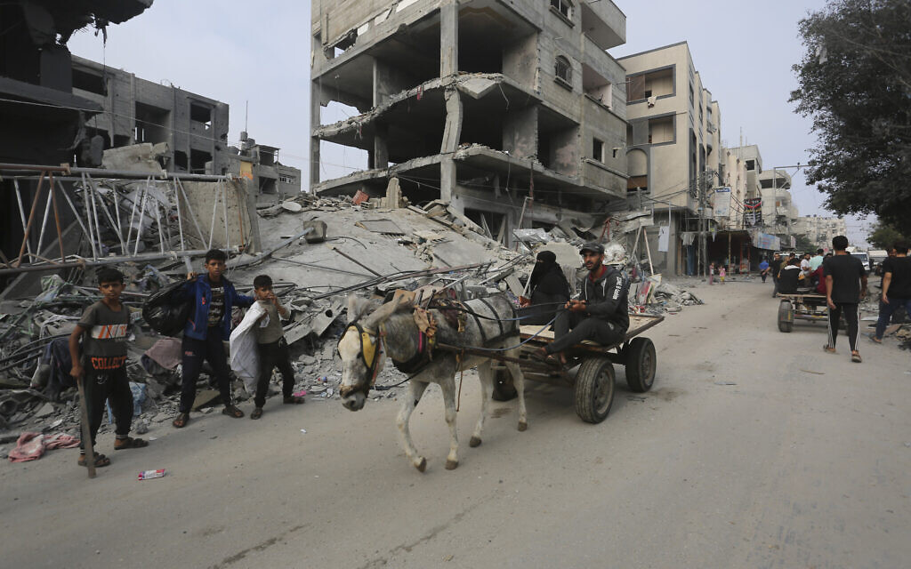 Palestinians pass by a destroyed building in Rafah in the Gaza Strip on Oct. 28, 2023. (AP Photo/Hatem Ali)