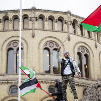 A man waves the Palestinian flag in front of the Norwegian Parliament building during a demonstration in Oslo, Oct. 28, 2023. (Frederik Ringnes/NTB via AP)