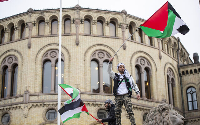 A man waves the Palestinian flag in front of the Norwegian Parliament building during a demonstration in Oslo, Oct. 28, 2023. (Frederik Ringnes/NTB via AP)