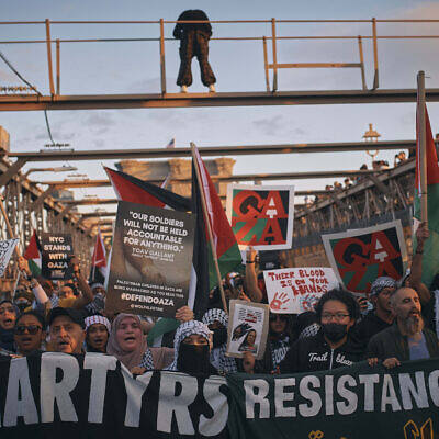 Palestinian supporters shout slogans as they cross the Brooklyn Bridge during a demonstration demanding a ceasefire in the Israel-Hamas war, praising Palestinian "resistance" and denouncing Israel, October 28, 2023, in New York. (AP Photo/Andres Kudacki)
