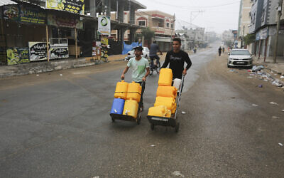 Palestinians push carts with water canisters in Rafah on Sunday, Oct. 29, 2023. (AP/Hatem Ali)