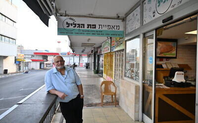 Avi Yosef-Hay stands at the entrance to his bakery in Kiryat Shmona, on October 22, 2023. (Canaan Lidor/Times of Israel)