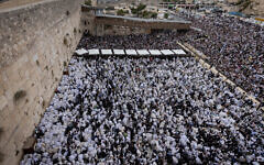 Jewish worshippers pray at the Western Wall, Judaism's holiest prayer site, in Jerusalem's Old City, during the Birkat HaKohanim priestly blessing at the Jewish holiday of Sukkot, October 2, 2023. (Chaim Goldberg/Flash90)
