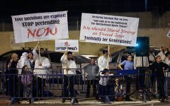 Dozens of Orthodox Jews hold signs reading 'Out with the Christians, Jews -Don't Enter' during a protest outside a Christian Embassy Feast of Tabernacles event, at the Pais Arena stadium in Jerusalem on October 3, 2023. (Chaim Goldberg/FLASH90)