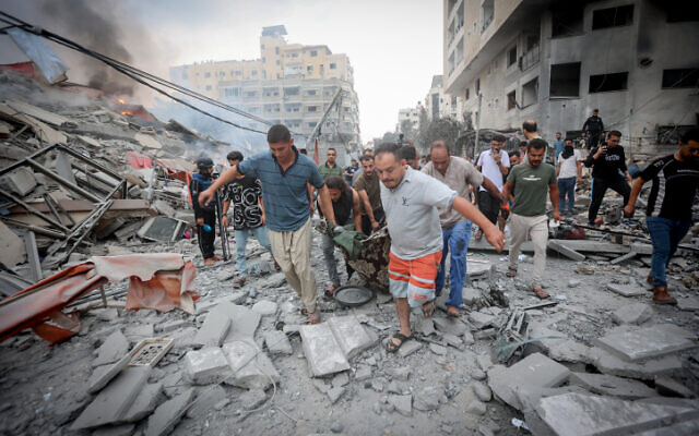 Gazans help the injured in Israeli airstrikes, October 10, 2023. (Atia Mohammed/Flash90)