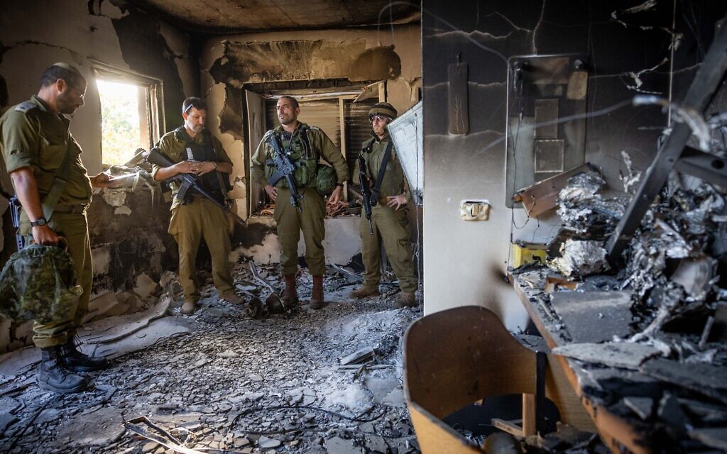 Israeli soldiers on October 17 amid the destruction of a home at Kibbutz Be'eri, near the Israeli-Gaza border, where Hamas terrorists killed over 100 residents on October 7, 2023. (Yonatan Sindel/Flash90)