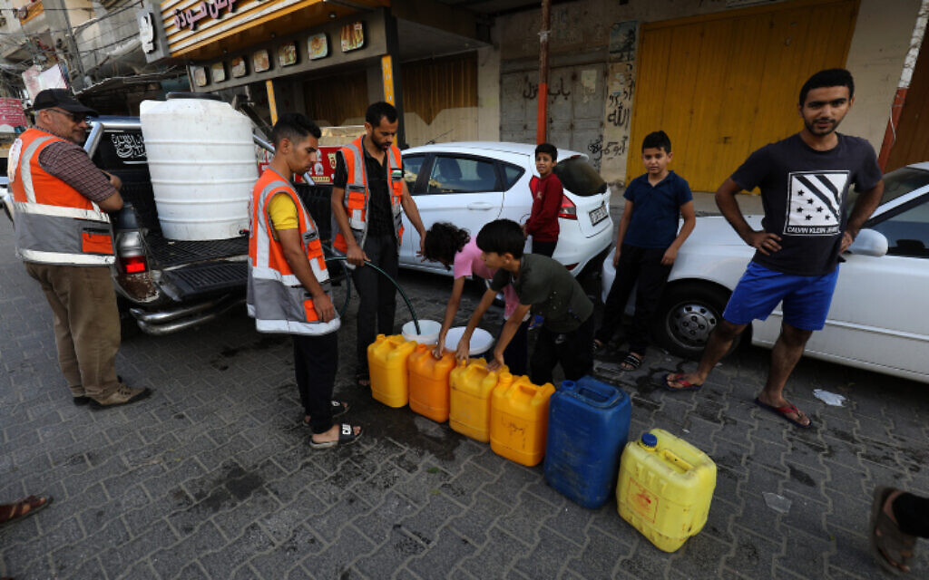 Palestinians fill containers with water in the city of Rafah in the southern Gaza Strip, October 20, 2023. (Abed Rahim Khatib/Flash90)