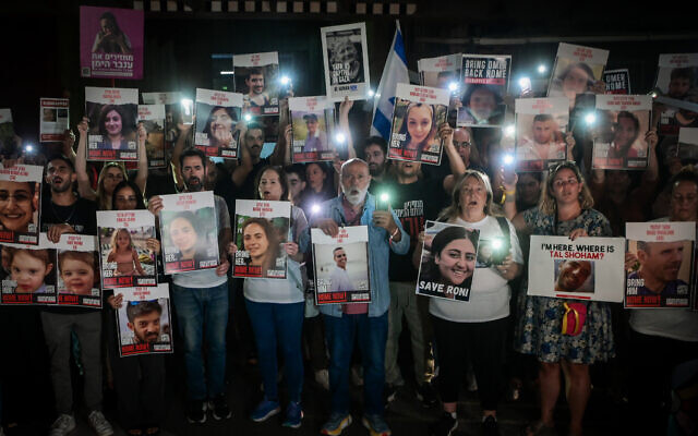 Families of Israelis held hostage by terrorists in Gaza hold up photographs of their abducted family members outside the Art Museum of Tel Aviv, October 21, 2023 (Avshalom Sassoni/Flash90)