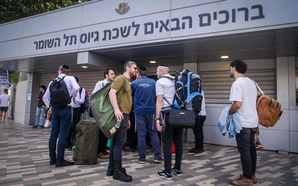 Ultra-Orthodox men arrive at the IDF recruiting offices in Tel Hashomer, near Tel Aviv, October 23, 2023. (Avshalom Sassoni/Flash90)