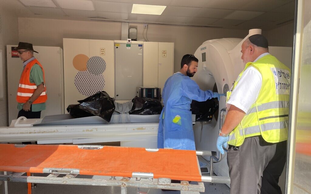 A victim of the murderous Hamas attack on southern Israeli communities on October 7, 2023 undergoes a CT scan at the National Center of Forensic Medicine (Abu Kabir) in Jaffa, October 16, 2023. (Renee Ghert-Zand/TOI)
