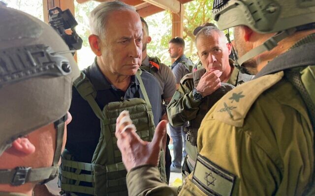Prime Minister Benjamin Netanyahu speaks to IDF officers at one of the communities hit by the deadly Hamas assault, on October 14, 2023 (Avi Ohayon/GPO)