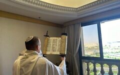 A member of Communications Minister Shlomo Karhi's delegation holds up a Torah scroll during a morning prayer service in Riyadh, Saudi Arabia, October 3, 2023. (Spokesman's Office, Communications Ministry)