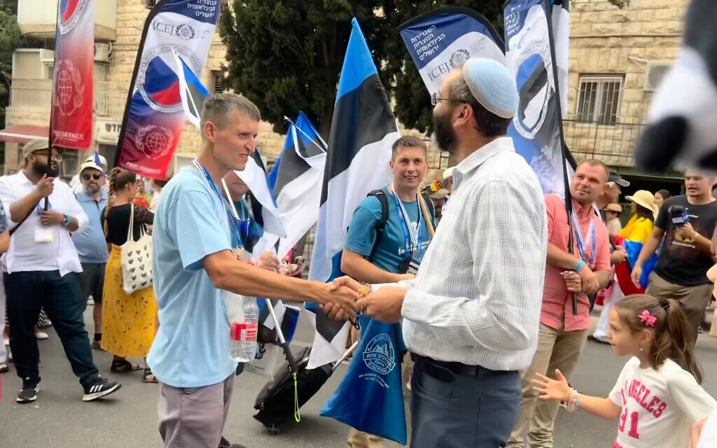 An Israeli man shakes hands with Estonian Zionists at the International Christian Embassy of Jerusalem march, October 4, 2023 (Lazar Berman/The Times of Israel)
