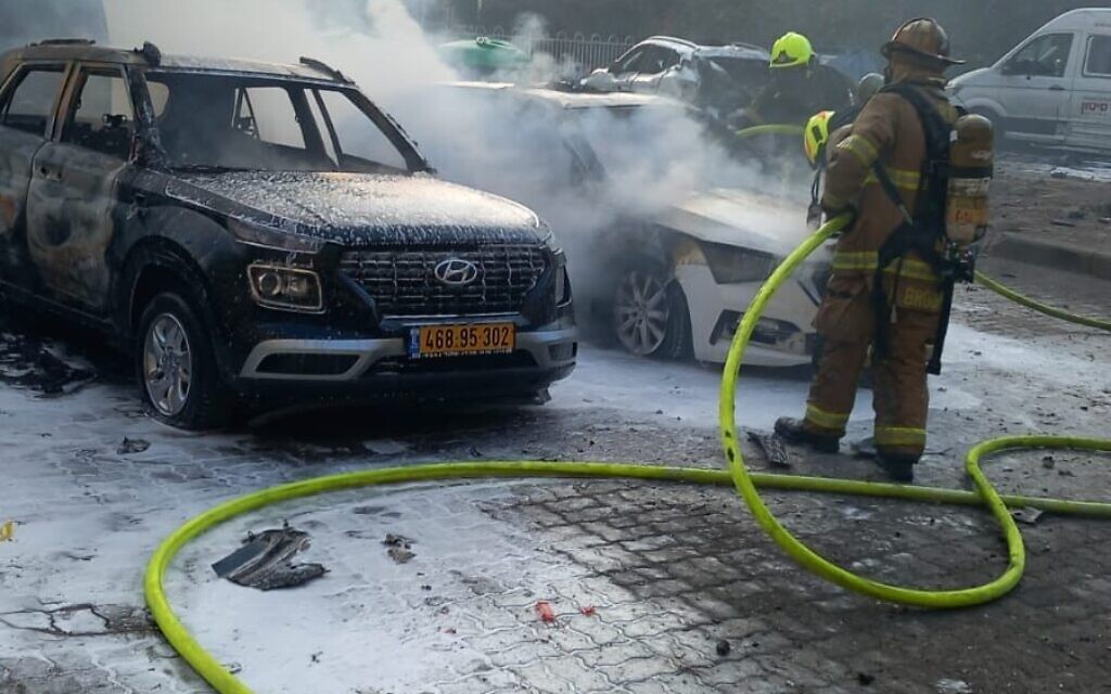 Firefighters extinguish a car fire caused by a rocket impact in Ashdod, October 31, 2023. (Fire and Rescue Services)