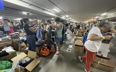 Volunteers help to sort and pack donated items at the Civilian Operations Hub, Expo Tel Aviv, October 19, 2023. (Sue Surkes/Times of Israel)