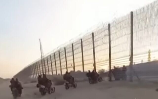FILE - Hamas terrorists are seen crossing the Israel-Gaza border fence on October 7, 2023. (Kan TV screenshot; used in accordance with Clause 27a of the Copyright Law)