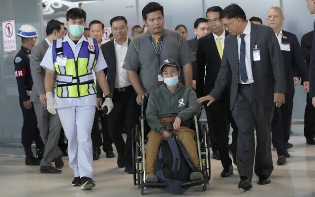 An injured Thai worker, front center, who was evacuated from Israel, arrives at Suvarnabhumi International Airport in Samut Prakarn Province, Thailand, October 12, 2023. (AP Photo/Sakchai Lalit)
